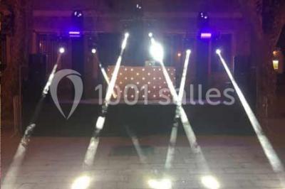 Platines DJ éclairées avec des boutons lumineux colorés et des reflets métalliques dans une ambiance sombre.