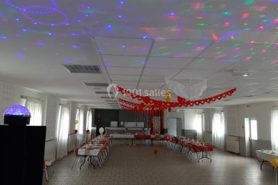 Des personnes dansent sous un abri décoré de ballons et guirlandes lumineuses, dans une ambiance festive nocturne.