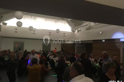 Des personnes dansent sous des lumières colorées dans une ambiance festive et tamisée.