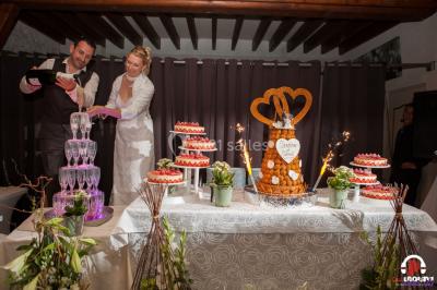 Des personnes dansent en ligne dans une salle décorée de ballons, avec des tables dressées et des convives en arrière-plan.