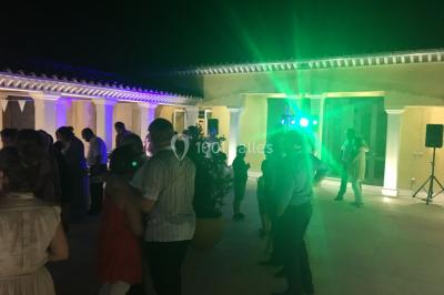 Miniature DJ Le Val (Var) - Enjoy-Your-Event #4 Personnes discutant dans une salle éclairée de lumières bleues, avec tables de buffet et décoration festive.