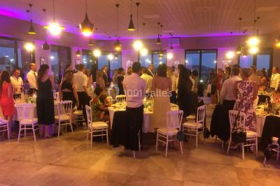 Miniature DJ Le Val (Var) - Enjoy-Your-Event #6 Personnes discutant dans une salle éclairée de lumières bleues, avec tables de buffet et décoration festive.