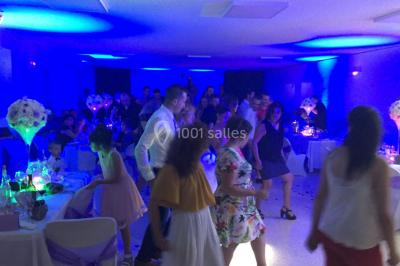 Miniature DJ Le Val (Var) - Enjoy-Your-Event #23 Personnes discutant dans une salle éclairée de lumières bleues, avec tables de buffet et décoration festive.