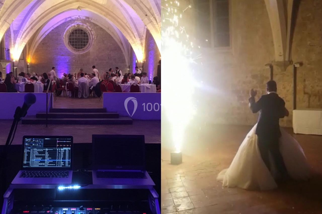 Salle voûtée éclairée pour un mariage, avec une table de mixage et un couple dansant près d'un effet pyrotechnique.
