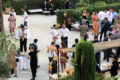 Miniature DJ Le Val (Var) - Enjoy-Your-Event #14 Personnes discutant dans une salle éclairée de lumières bleues, avec tables de buffet et décoration festive.