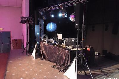 Un couple dansant en silhouette dans une ambiance tamisée, entouré de convives flous en arrière-plan.