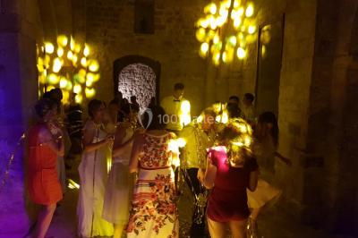 Salle avec éclairage de scène coloré, piste de danse illuminée, tables sur les côtés et matériel audio en arrière-plan.