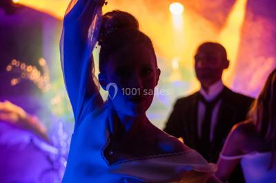 Deux femmes dansent et discutent dans une ambiance festive avec des lumières colorées.