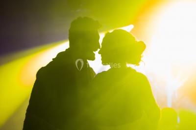 Deux femmes dansent et discutent dans une ambiance festive avec des lumières colorées.