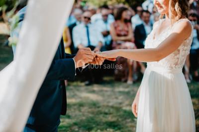 Des personnes dansent et lèvent les bras dans une ambiance festive, éclairée par des lumières colorées.