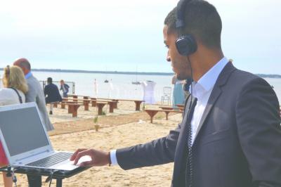 Des personnes dansent et lèvent les bras dans une ambiance festive, éclairée par des lumières colorées.