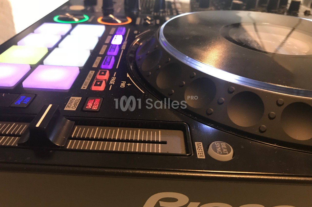 Platine DJ avec boutons lumineux, plateau rotatif et curseur de réglage, vue en gros plan.
