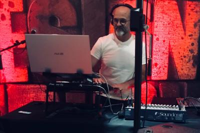 Salle décorée avec un sapin de Noël, éclairages colorés au sol et matériel de DJ installé sur une estrade.