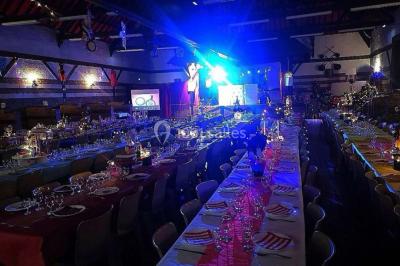 Un homme et une femme sourient devant un fond décoré de feuillage et de rideaux blancs.