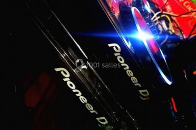 Un homme et une femme sourient devant un fond décoré de feuillage et de rideaux blancs.