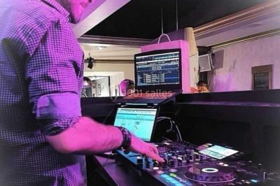 Un homme et une femme sourient devant un fond décoré de feuillage et de rideaux blancs.