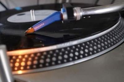 Un homme et une femme sourient devant un fond décoré de feuillage et de rideaux blancs.