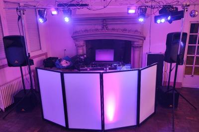 Un homme et une femme sourient devant un fond décoré de feuillage et de rideaux blancs.