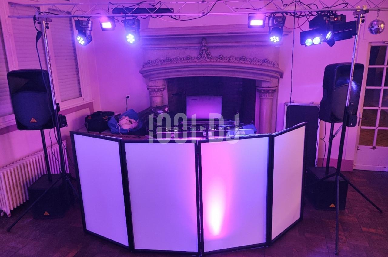 Installation de matériel de sonorisation et éclairage avec une table de mixage devant une cheminée dans une salle.