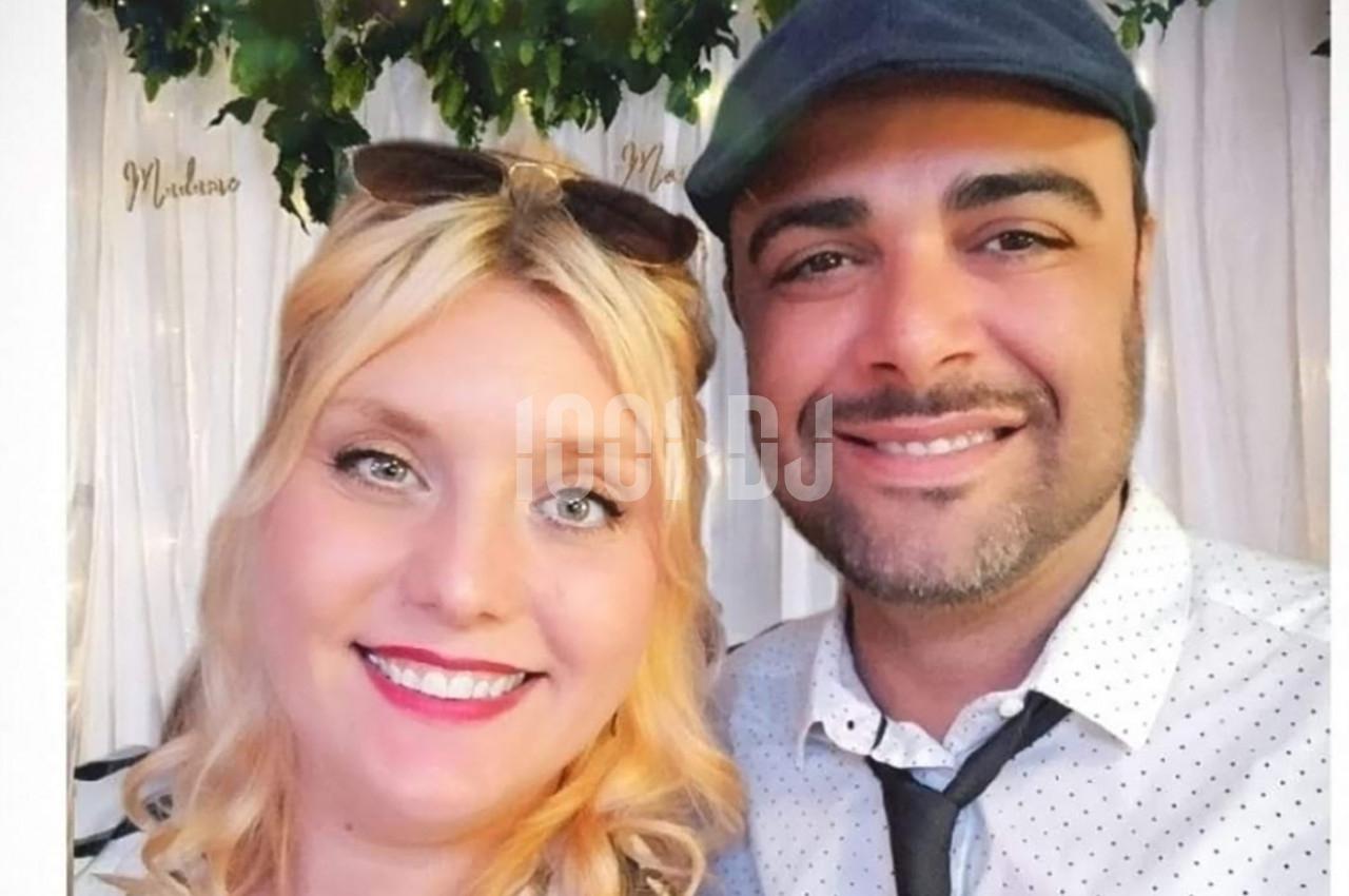 Un homme et une femme sourient devant un fond décoré de feuillage et de rideaux blancs.