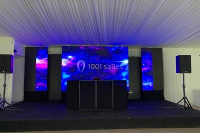 Miniature DJ Montlhéry (Essonne) - AmbianCvous #18 Grande tente transparente aménagée avec des tables alignées, décorées de fleurs et de vaisselle pour un événement.