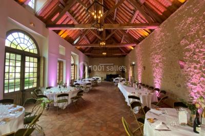 Groupe de musiciens jouant sur une scène couverte en plein air, éclairée par des lumières colorées, avec un public devant.