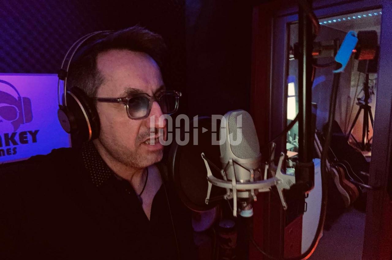 Homme portant un casque audio enregistrant sa voix devant un microphone dans un studio d'enregistrement.