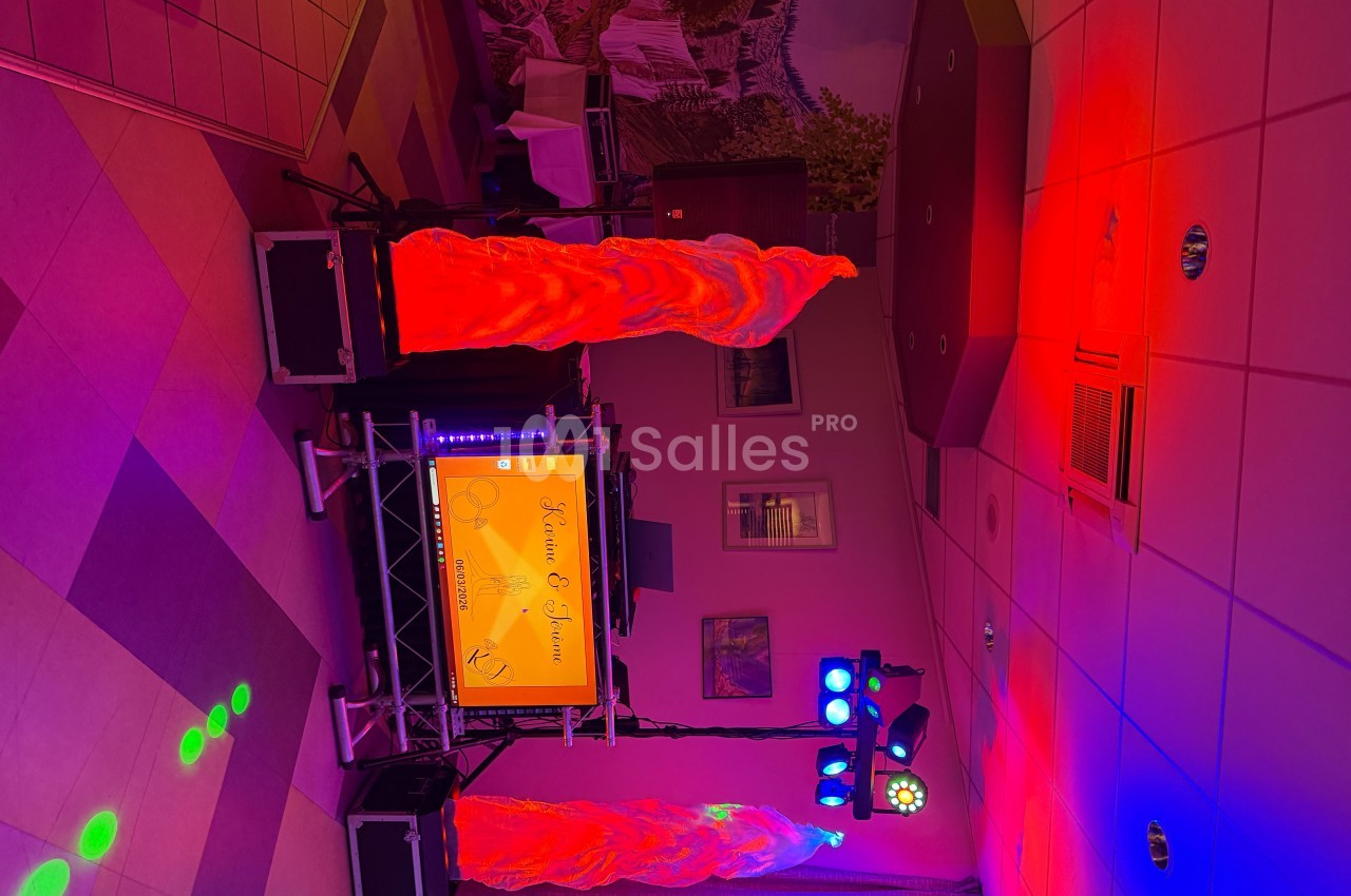 Installation de matériel de sonorisation et éclairage coloré dans une salle avec décor mural et plafond carrelé.