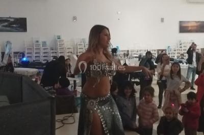 Deux mains entrelacées sur une table, avec des verres et une ambiance romantique en arrière-plan.