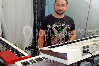 Deux mains entrelacées sur une table, avec des verres et une ambiance romantique en arrière-plan.