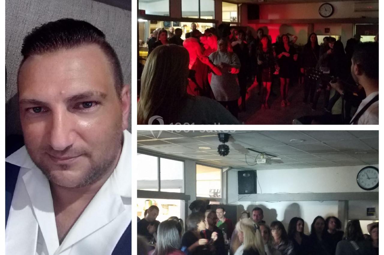Homme en chemise blanche en gros plan à gauche, soirée dansante avec plusieurs personnes en arrière-plan à droite.