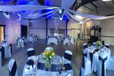Miniature DJ Troarn (Calvados) - Keops Animations #23 Salle de réception décorée avec des tables rondes dressées, des nappes blanches et des éclairages bleutés.