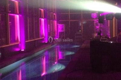 Salle de réception décorée avec des voilages blancs, des tables dressées et des chaises couvertes de housses.