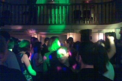 Un couple en tenue de mariage s'embrasse sous une pluie de confettis dans un intérieur festif.