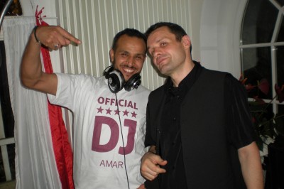 Un couple en tenue de mariage s'embrasse sous une pluie de confettis dans un intérieur festif.