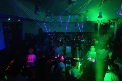 Miniature DJ Belhade (Landes) - Caribbean Sounds #12 Groupe de personnes réunies en soirée en plein air, éclairées par des guirlandes lumineuses et des lampadaires.