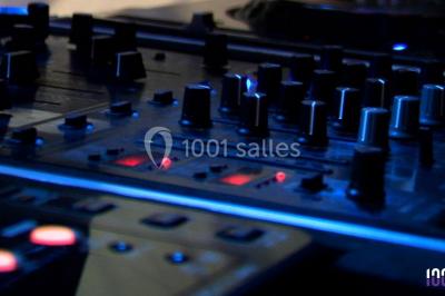 Groupe de personnes réunies en soirée en plein air, éclairées par des guirlandes lumineuses et des lampadaires.