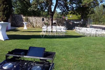 Des personnes dansent sous des lumières rouges dans une salle ornée de décorations murales et de lustres.