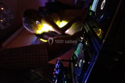 Des personnes dansent sous des lumières rouges dans une salle ornée de décorations murales et de lustres.