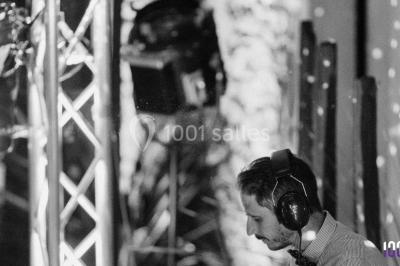 Un couple danse sur une piste éclairée par des lumières colorées, entouré de spectateurs dans une salle festive.