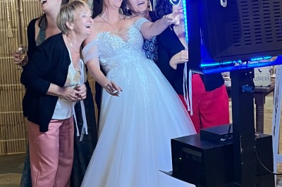 Salle décorée pour un événement avec éclairage violet, machines à fumée et équipements audio devant une baie vitrée.