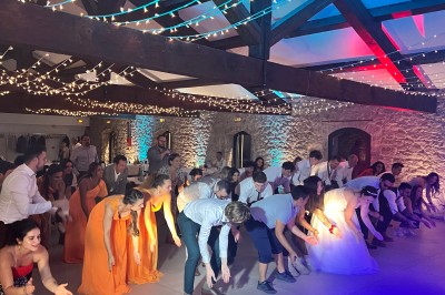 Salle décorée pour un événement avec éclairage violet, machines à fumée et équipements audio devant une baie vitrée.