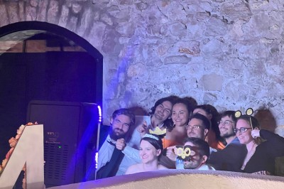 Salle décorée pour un événement avec éclairage violet, machines à fumée et équipements audio devant une baie vitrée.