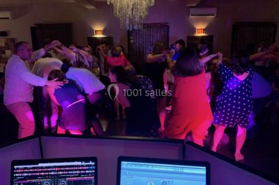 Deux hommes sur scène, l'un chante au micro tandis que l'autre pointe du doigt près d'un équipement audio.