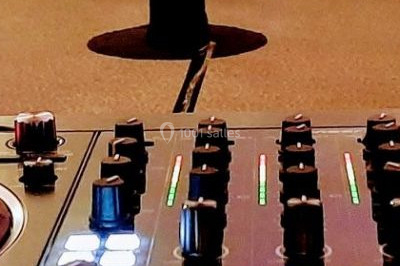 Miniature DJ Saint-Étienne-la-Thillaye (Calvados) - Tuxedo-prod #11 Scène de concert avec batterie, guitares, claviers et micros sous un éclairage coloré.