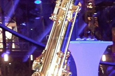 Miniature DJ Saint-Étienne-la-Thillaye (Calvados) - Tuxedo-prod #12 Scène de concert avec batterie, guitares, claviers et micros sous un éclairage coloré.