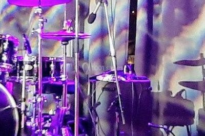 Miniature DJ Saint-Étienne-la-Thillaye (Calvados) - Tuxedo-prod #14 Scène de concert avec batterie, guitares, claviers et micros sous un éclairage coloré.