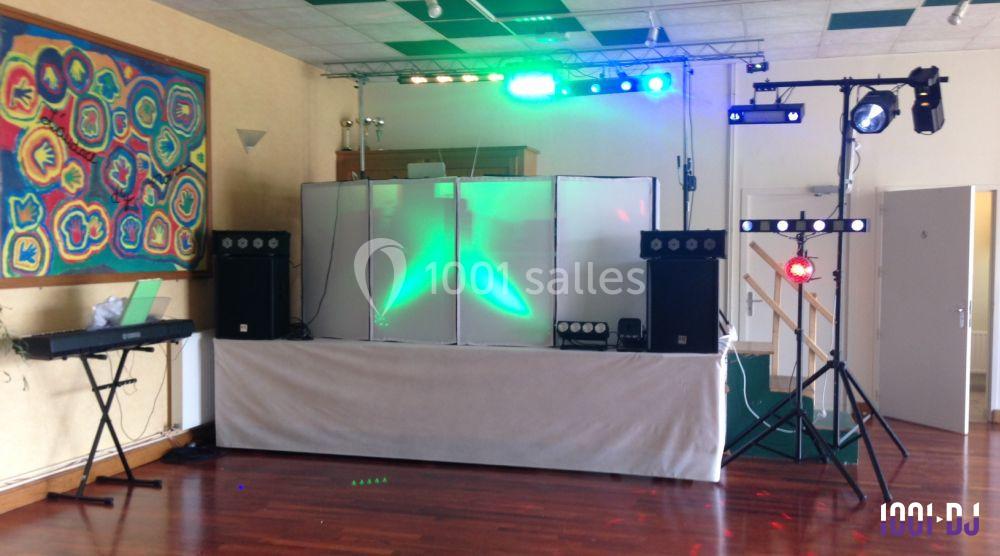 Équipement de sonorisation et éclairage coloré installé dans une salle avec un clavier électronique à gauche.