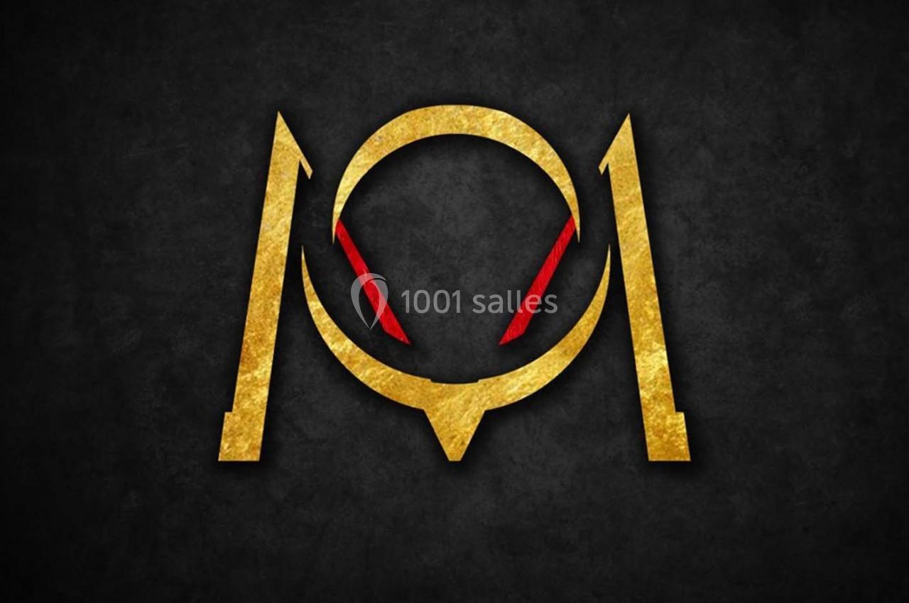 Logo doré stylisé avec des accents rouges sur fond noir texturé.