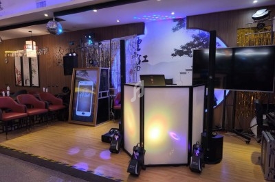 Un DJ mixant de la musique sur une table de mixage éclairée par des lumières colorées dans une ambiance nocturne.